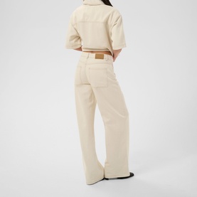 Model wearing Kaffe off white washed wide-leg trousers with matching jacket, styled with a tan belt and black shoes, rear view.
