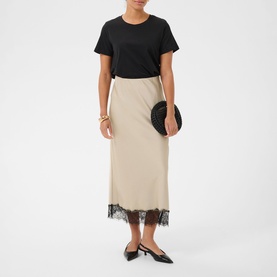 Model wearing Kaffe Feather Gray midi skirt with black lace hem, styled with black T-shirt and slingback heels, carrying round clutch bag