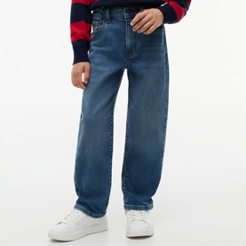 Model wearing Tommy Hilfiger vintage medium stretch jeans in blue, styled with white trainers and a navy striped jumper
