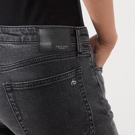 Model wearing Rag & Bone Straight jeans in angela grey denim, close-up of back pocket with logo patch and branded hardware detail.