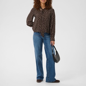Model wearing Kaffe Coffee Bean Turtledove print blouse with long sleeves, styled with blue wide-leg jeans and a grey shoulder bag.