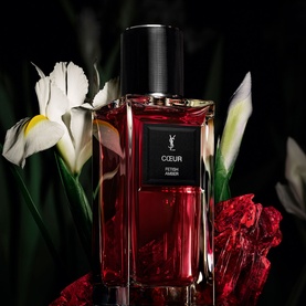 YSL Coeur Eau de Parfum, deep red bottle with black cap, styled with white iris and red florals on dark background