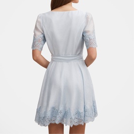 Model wearing pale blue mini dress with lace trim hem and sleeves, belted waist, back view