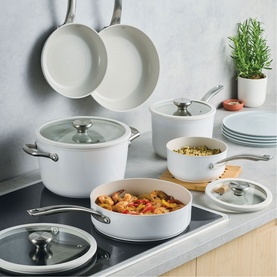 Circulon Halo with LaserDefense&trade; 6 Piece Non Stick Ceramic Cookware Set in white, styled on a kitchen hob with food and stacked plates