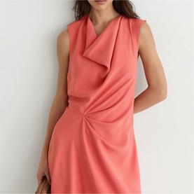 Model wearing Reiss coral pink sleeveless dress with draped neckline and ruched waist detail.