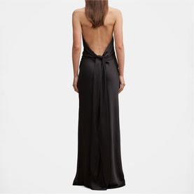 Model wearing black satin maxi dress with open low back, bow detail, and thin straps, shown from behind