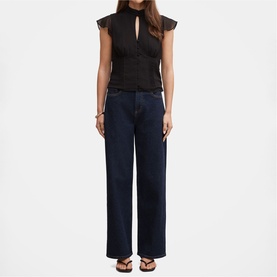 Model wearing dark navy wide-leg jeans styled with a black lace sleeveless top and black flat sandals