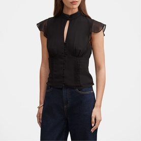 Model wearing black sheer flutter-sleeve blouse with keyhole neckline, button front, and corseted waist, styled with dark blue jeans