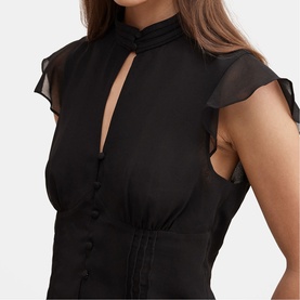Model wearing black sheer flutter-sleeve blouse with keyhole neckline, ruffle trim, and button-front detail