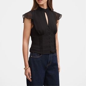 Model wearing black sheer flutter-sleeve blouse with keyhole neckline and pintuck detail, styled with dark blue jeans