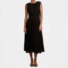 Model wearing black sleeveless midi dress with pleated chiffon skirt, styled with black strappy heels