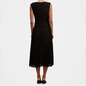 Model wearing black sleeveless midi dress with pleated skirt, styled with black heels, rear view