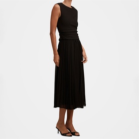 Model wearing black sleeveless midi dress with pleated skirt and ruched waist detail, styled with black heeled mules