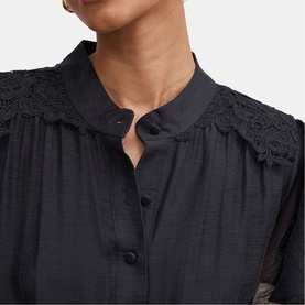 Model wearing black button-front blouse with lace shoulder detail and scalloped trim, close-up of neckline and yoke
