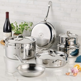 Hestan ProBond Luxe stainless steel cookware set displayed on kitchen counter, featuring pots, pans, and lids with polished finish.