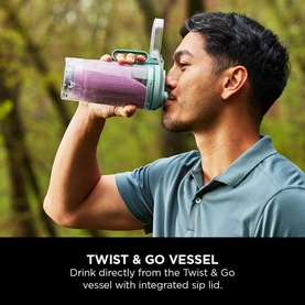 Model drinking from Ninja Blast Max Cordless Portable Blender Seaglass Twist & Go vessel with integrated sip lid, outdoors
