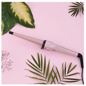Remington Curling Wand in pink, tapered barrel design, styled on pink background with tropical leaves