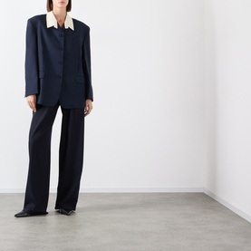 Model wearing navy tailored blazer with contrast cream collar and matching wide-leg trousers, styled with black pointed heels