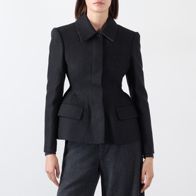 Model wearing black wool blend blazer with structured shoulders, peplum hem, flap pockets and concealed front fastening, styled with grey trousers