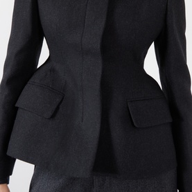 Black wool-blend blazer with structured peplum waist, flap pockets and fitted silhouette, close-up detail view