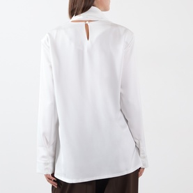 Model wearing white long-sleeve shirt, back view showing keyhole neckline cutout detail