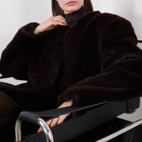 Model wearing Source Unknown Dhanila Faux Fur Coat in brown, longline with structured shoulders, paired with black turtleneck