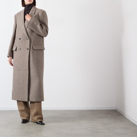 Model wearing Source Unknown Reyna Double-Breasted Coat in beige wool, longline with peak lapels, styled with wide-leg trousers and black heels