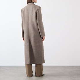 Model wearing Source Unknown Reyna Double-Breasted Coat in beige wool, longline silhouette with rear vent, styled with wide-leg trousers