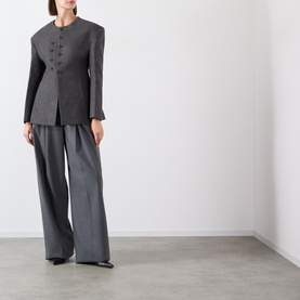 Model wearing Source Unknown Banton Double-Breasted Jacket in charcoal, collarless with structured shoulders, styled with wide-leg grey trousers.