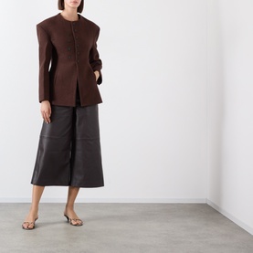 Model wearing Source Unknown Banton Double-Breasted Jacket in brown, collarless with structured shoulders, styled with dark leather midi skirt and