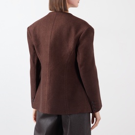 Model wearing Source Unknown Banton Double-Breasted Jacket in brown, collarless with structured shoulders, shown from behind with grey trousers.