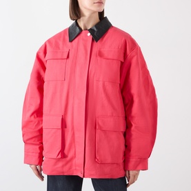 Model wearing Source Unknown Baia Fleece Field Jacket in red with contrast black collar, four front pockets, paired with dark jeans.