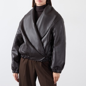 Model wearing Source Unknown Eleni Faux Leather Jacket in brown, shawl collar wrap style with elasticated trims, styled with dark trousers