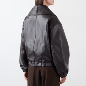 Model wearing Source Unknown Eleni Faux Leather Jacket in brown, faux leather finish, shawl collar, dropped shoulders, elasticated hem, back view