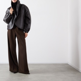 Model wearing Source Unknown Eleni Faux Leather Jacket in brown with shawl collar, styled with wide-leg dark brown trousers.