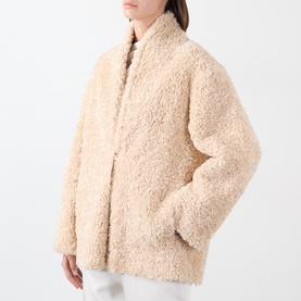 Model wearing Source Unknown Manuela Shearling Jacket in beige, with shawl collar, dropped shoulders, and faux shearling texture