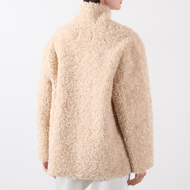 Model wearing Source Unknown Manuela Shearling Jacket in beige, back view showing faux shearling texture, dropped shoulders and high neck