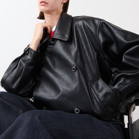 Model wearing Source Unknown Viellino Faux Leather Jacket in black, double-breasted with shirt collar and dropped shoulders, styled with dark trousers