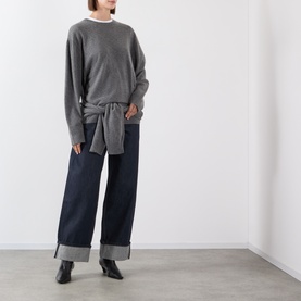 Model wearing Source Unknown Piero Wide Leg Jeans in blue dark wash with turn-up hems, styled with a grey knit sweater and black ankle boots.