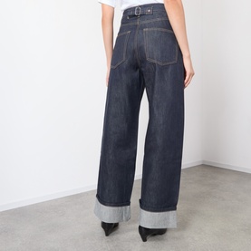 Model wearing Source Unknown Piero Wide Leg Jeans in blue, high-rise wide-leg cut, turn-up hems, tobacco stitching, dark wash, rear view