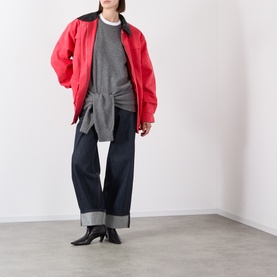 Model wearing Source Unknown Piero Wide Leg Jeans in blue dark wash with turn-up hems, styled with red bomber jacket and grey knit.