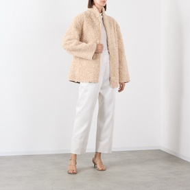 Model wearing Source Unknown Kuna Asymmetric Blouse in ivory, styled with white trousers and nude heeled sandals, full-length view.