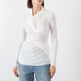 Model wearing Source Unknown Folgore Draped Top in ivory with asymmetric neckline, ruched detailing and long sleeves, styled with blue jeans
