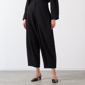 Model wearing Source Unknown Bimba Pintuck Trousers in black, wide-leg cropped style with pintuck detail, styled with black slingback heels.