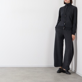 Model wearing Source Unknown Ebbe Balloon Trousers in charcoal, styled with a matching dark zip-up cardigan and black loafers.