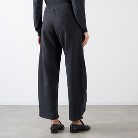 Model wearing Source Unknown Ebbe Balloon Trousers in charcoal, showing rear elasticated waistband and wide balloon-leg silhouette, styled with black