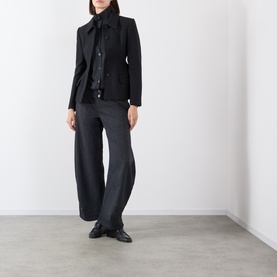 Model wearing Source Unknown Ebbe Balloon Trousers in charcoal, wide balloon leg, styled with black blazer and loafers.