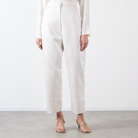 Model wearing Source Unknown Ocelia Satin Trousers in white, cropped straight-leg silhouette, styled with a white top and strappy heeled sandals.