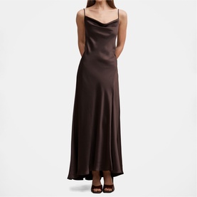 Model wearing dark brown satin cowl neck maxi slip dress with thin straps, styled with black heeled sandals