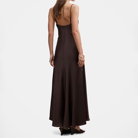 Model wearing dark brown satin slip maxi dress with thin shoulder straps, low back, and flared skirt, styled with black heels.